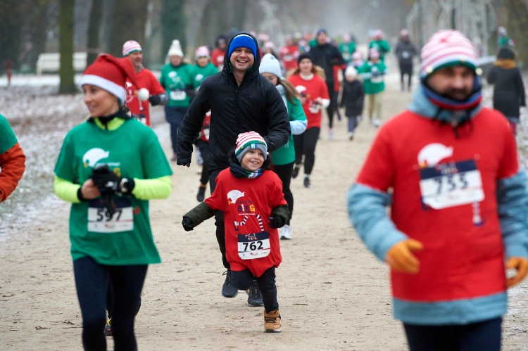 biegnąca grupa osób w czapkach św. Mikołaja